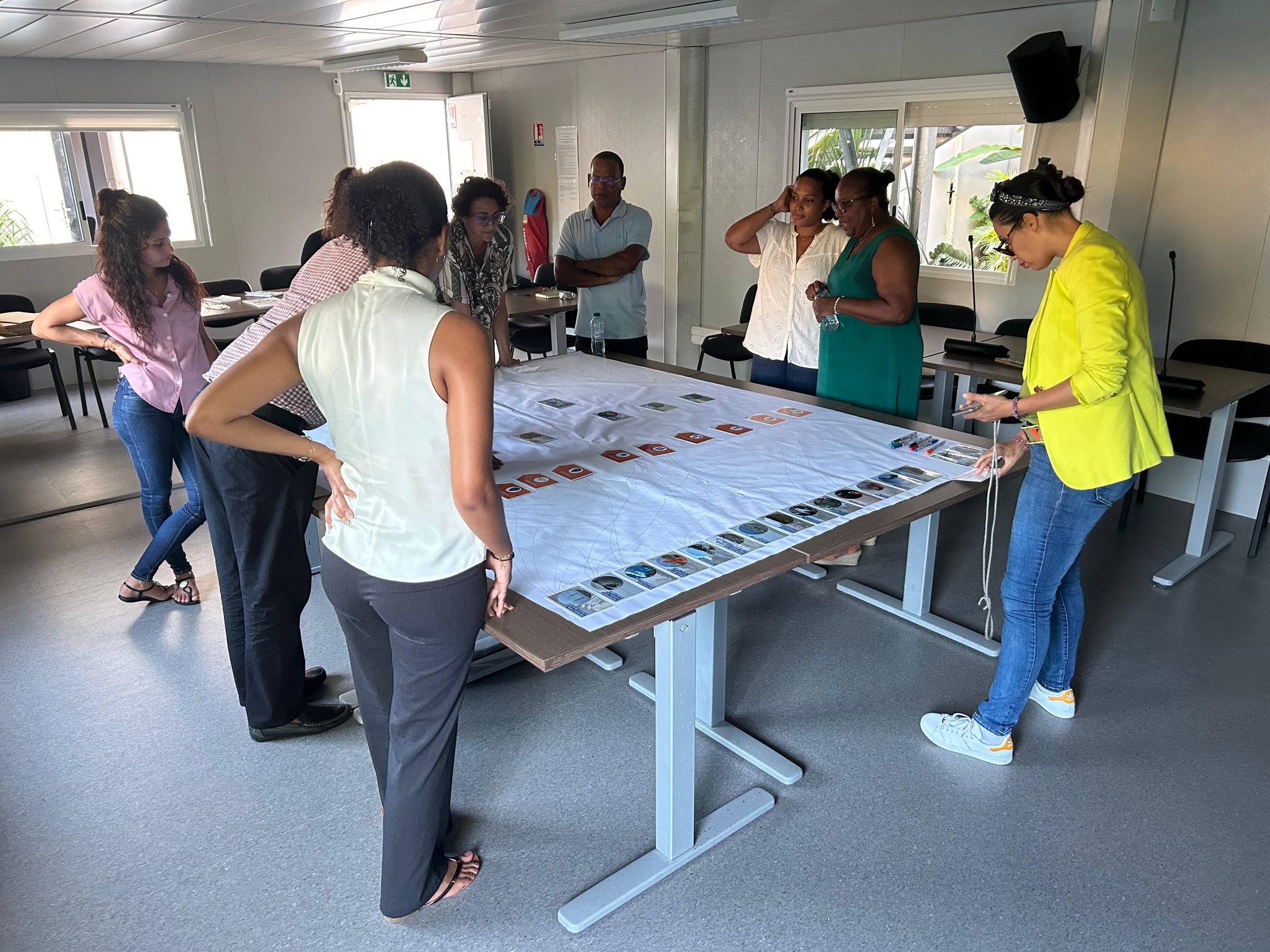 7 participants + 2 animatrices autour d'une table réalisant la Fresque